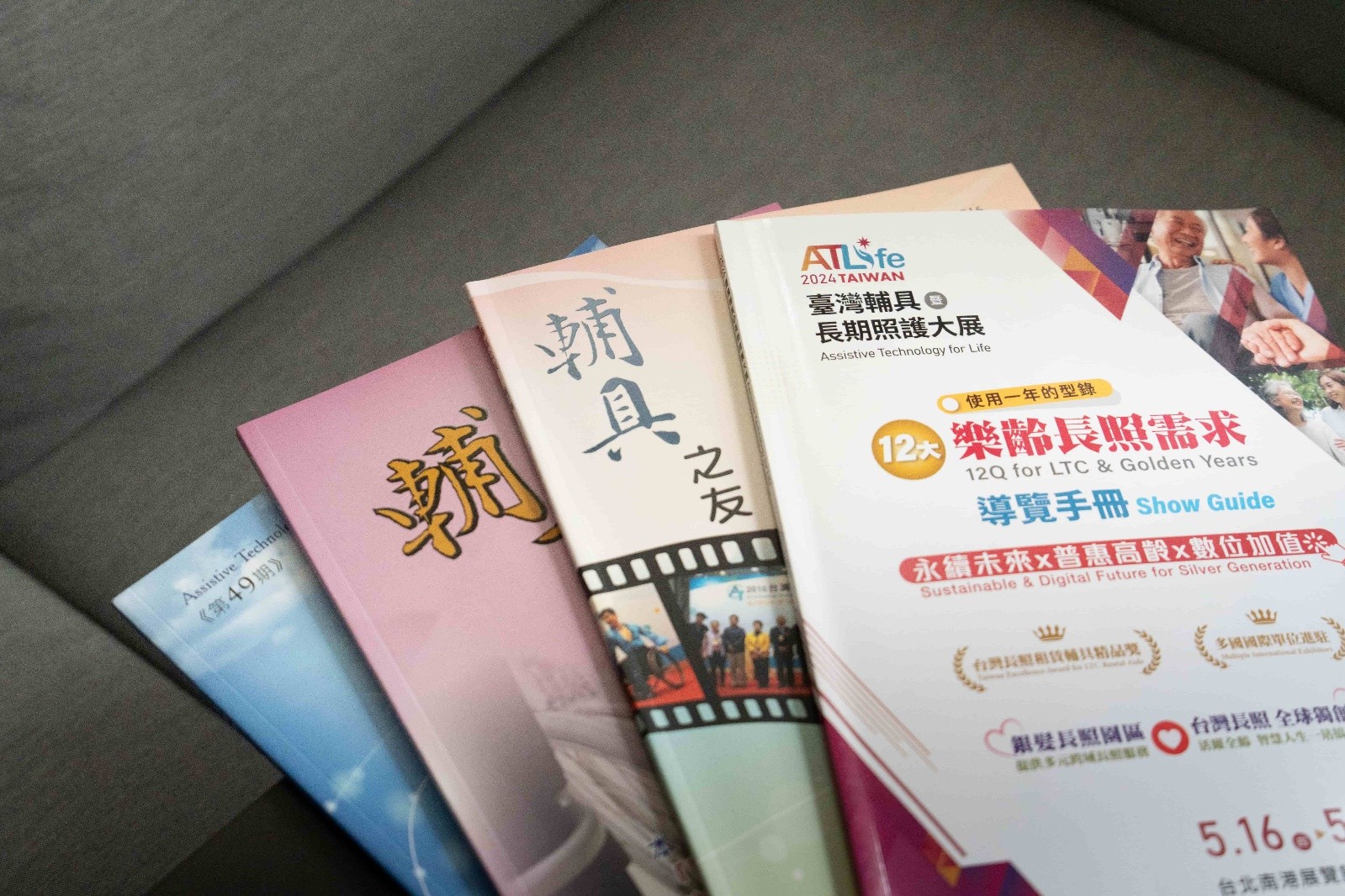 多本與輔具及臺灣輔具暨長期照護大展相關的出版品整齊擺放於桌面上。